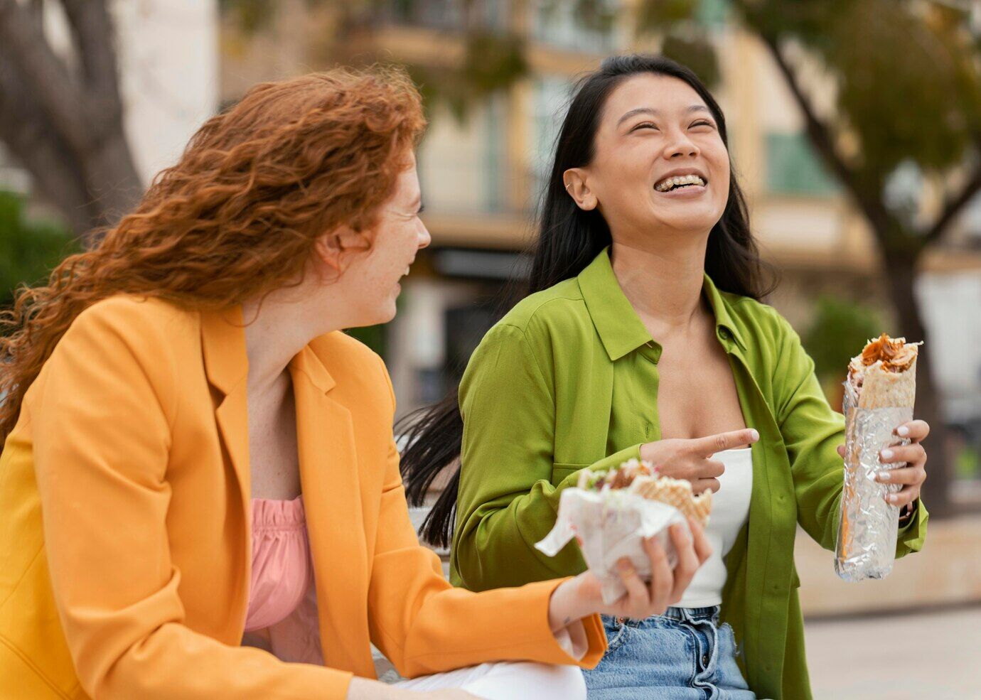 Happy women eating together street food