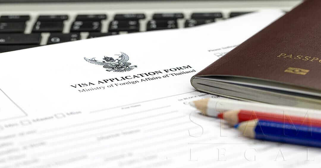 Image of a visa application form by the Ministry of Foreign Affairs of Thailand with three color pencils and a passport on the side.