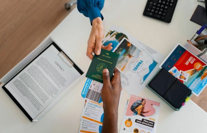A person handing their passport and business visa