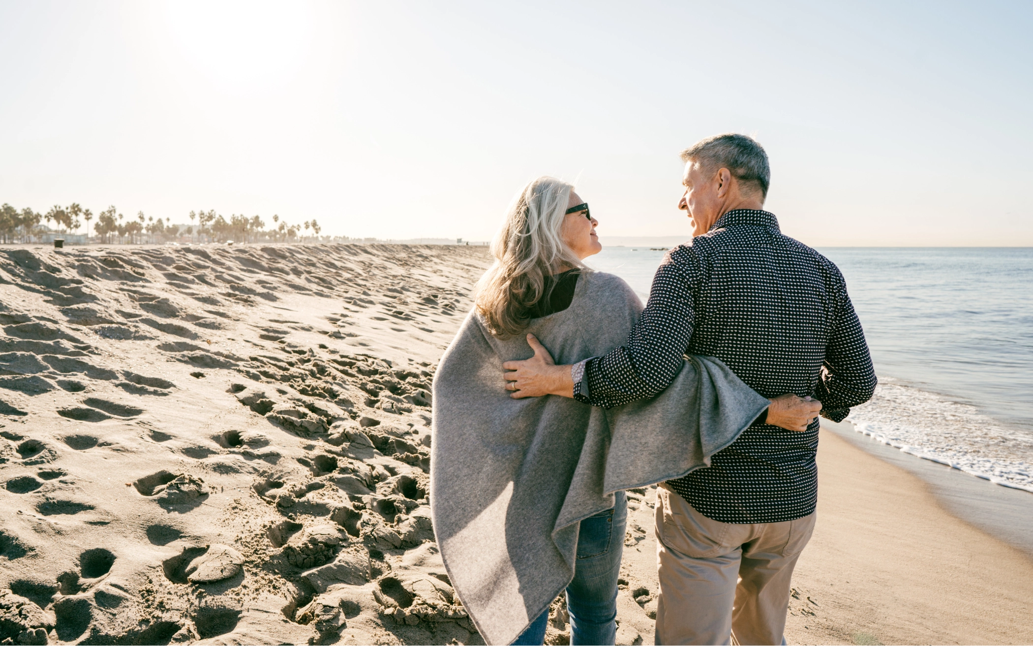 retired couple walking on the beach