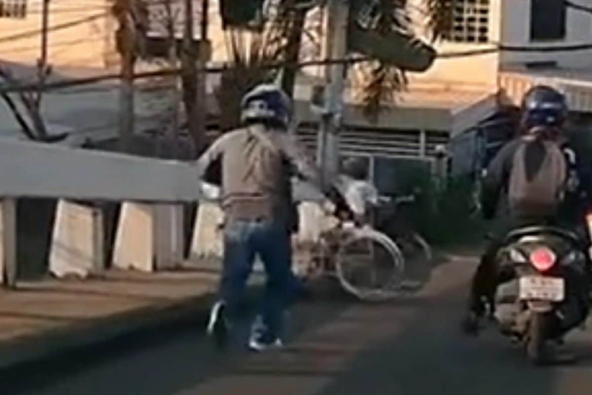 Thai motorcyclist helps disabled man cross bridge