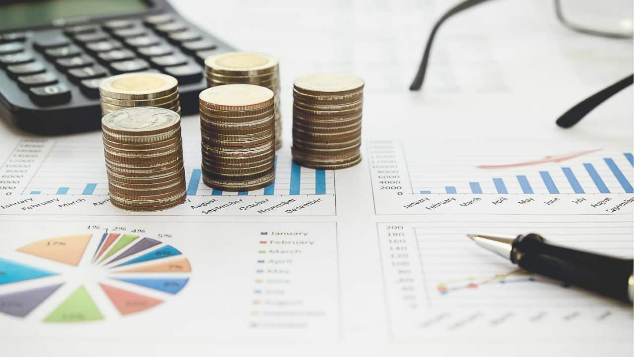 Money on the table with some graphs underneath it