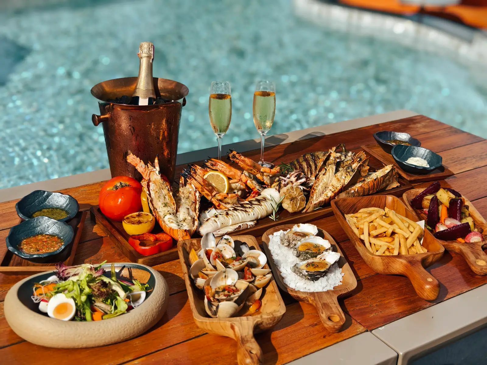 Gourmet seafood platter with champagne served poolside at Nora Beach Club Phuket, Thailand