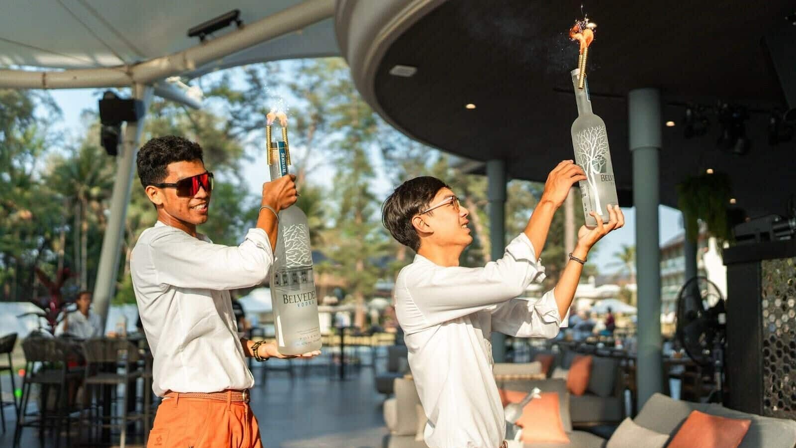 Bartenders performing a bottle show with sparkles at a beach club in Phuket, Thailand