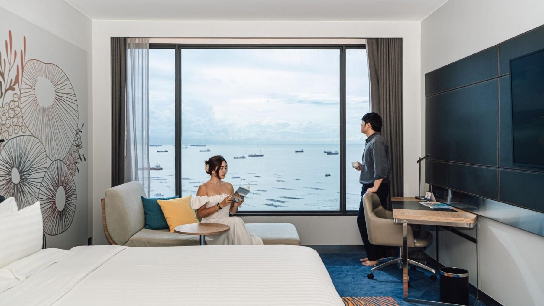 Modern hotel room with sea view and couple enjoying a quiet moment