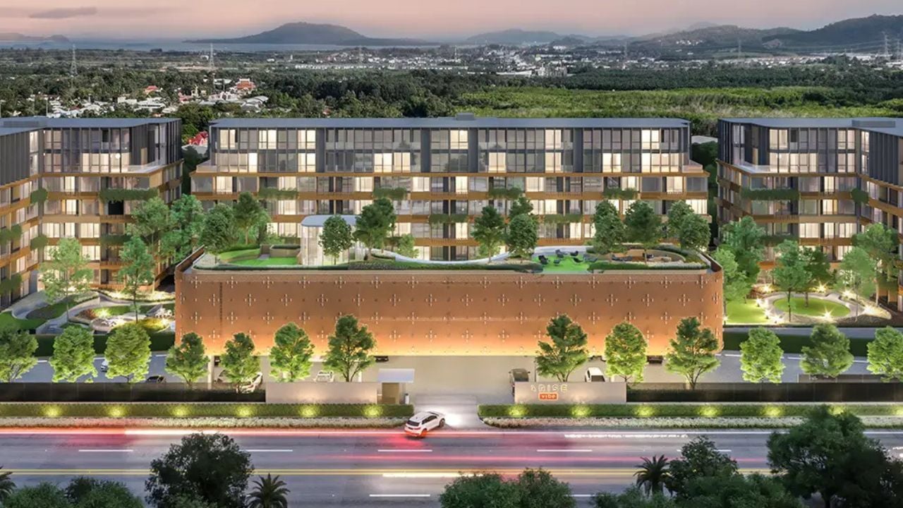 Modern luxury condominium building in Phuket with landscaped gardens and city backdrop, offering a nice place to live in Phuket.