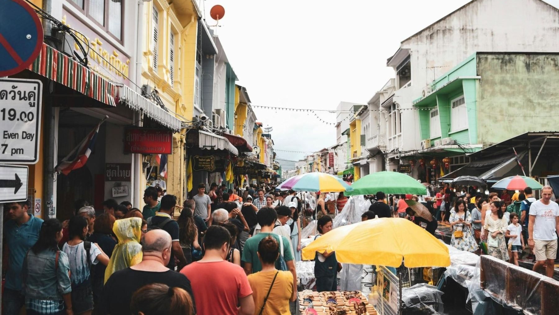 Crowds exploring the colorful Sunday market at Phuket Old Town with shops and street vendors, making it one of the best places to live in Phuket