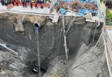 Bangkok road sinkhole subsides further, threatening nearby building structure | Thaiger