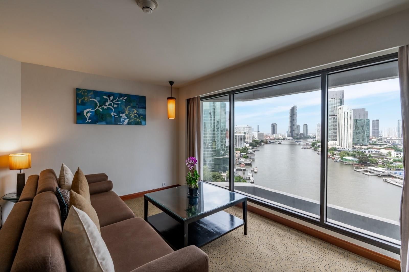 The living room of Executive Suite at Royal Orchid Sheraton has uninterrupted views of the Chao Phraya River