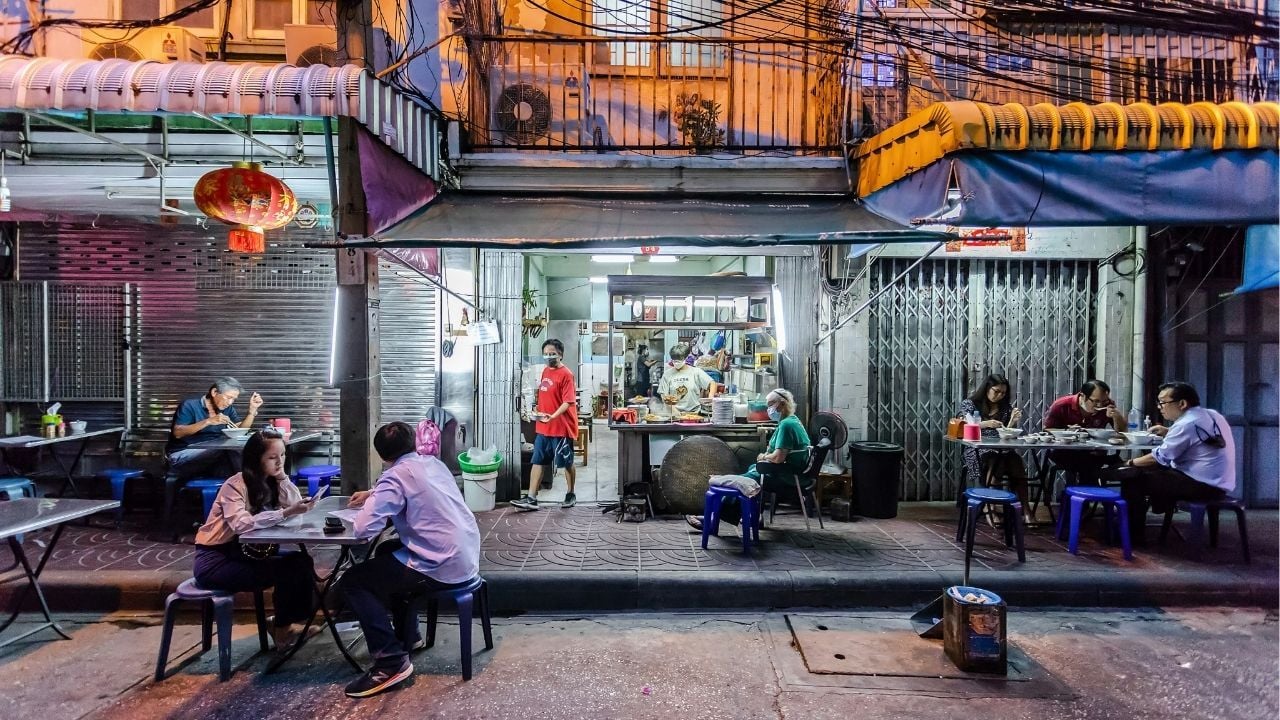 People eating outside in Bangkok at night | Photo by Streets of Food on Unsplash
