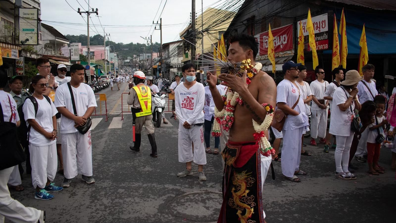 Men and women puncture their cheeks with sharp items, including knives and skewers on the Vegetarian Festival.