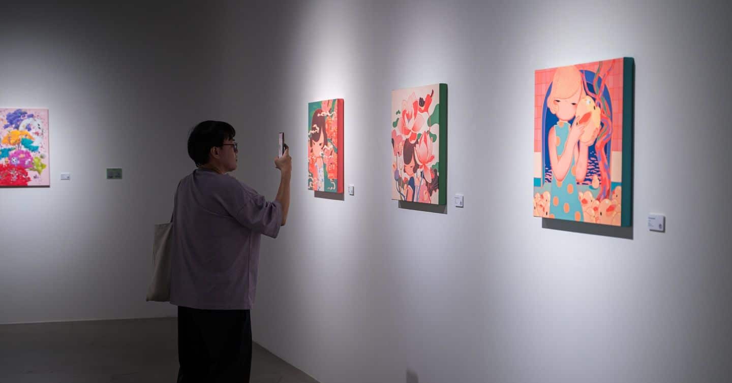 A man taking a photo of an artwork at Color Pulse, an art exhibition in Bangkok, Thailand