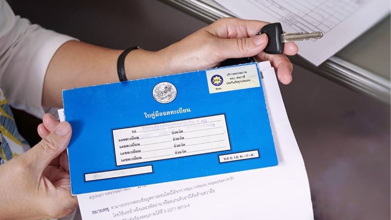 A blue book for vehicle registration required for road tax in Thailand.