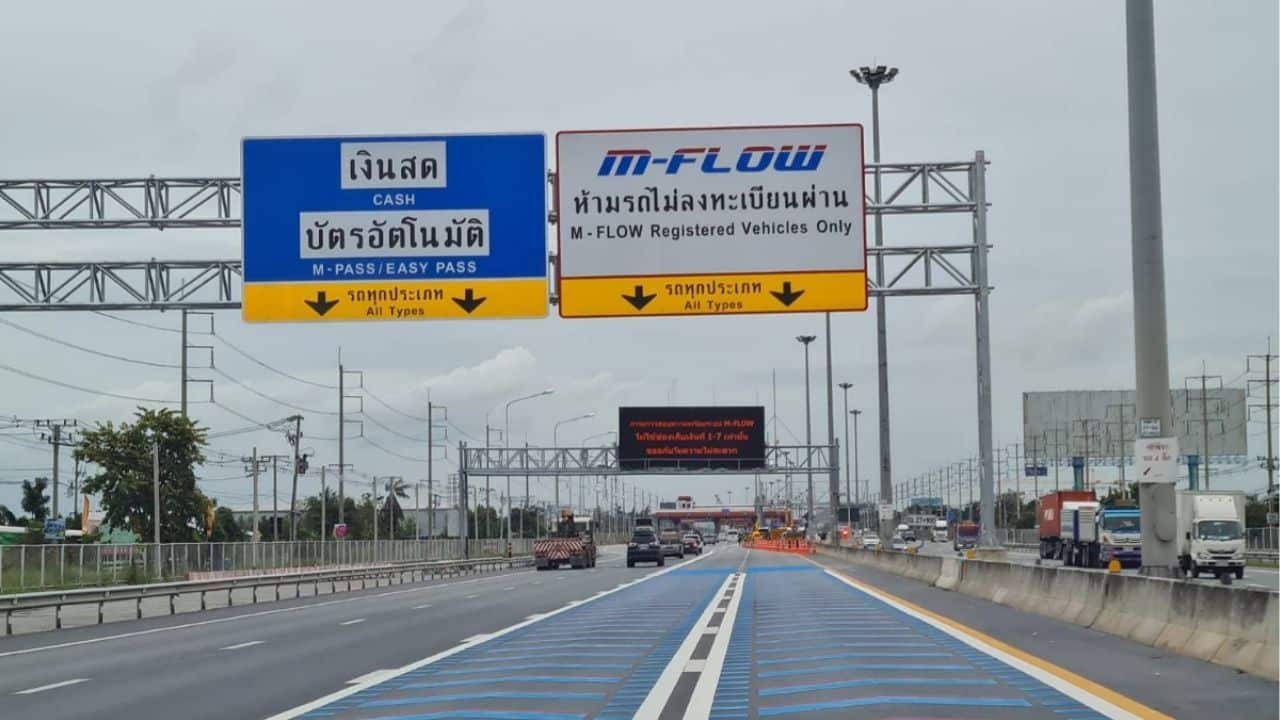 A sign indicating cash, Easy Pass, and M-Flow lanes on Thailand's toll road.