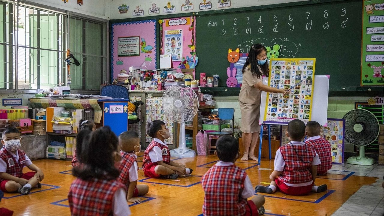 Teachers interacting with students in a vibrant school in Thailand during a language class.
