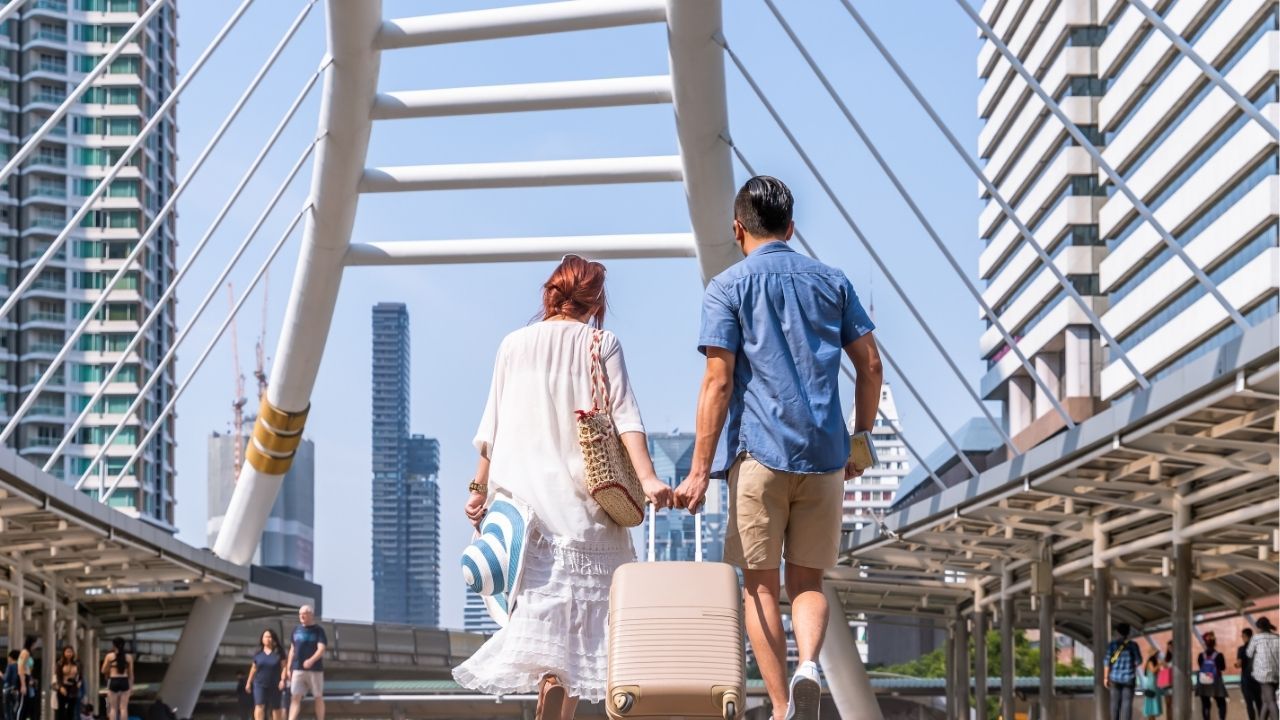 A couple walks on Chong Nonsi Bridge, highlighting Bangkok's vibrant lifestyle and affordable cost of living.