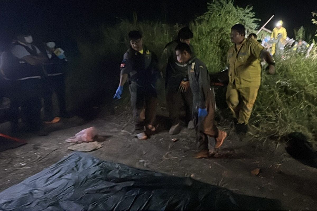 Thai police officers and forensic team investigate the scene where a man was found dead under a collapsed shack in Pathum Thani.