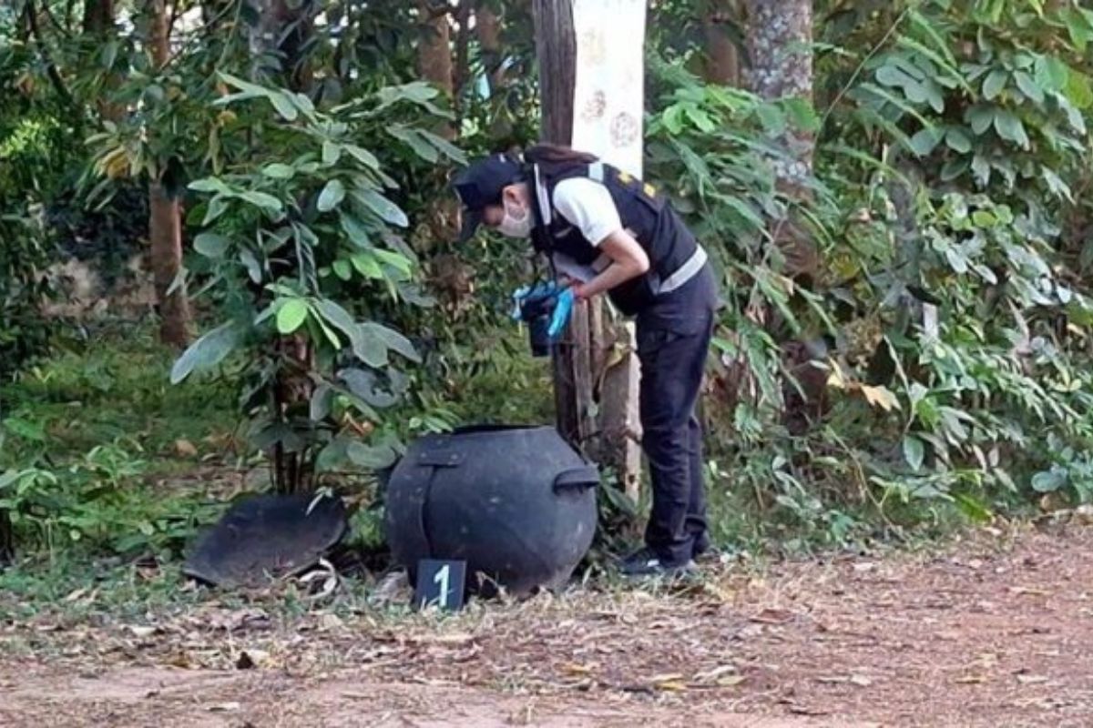 Forensic officer photographs evidence at the scene where a newborn’s body was found in Nakhon Phanom