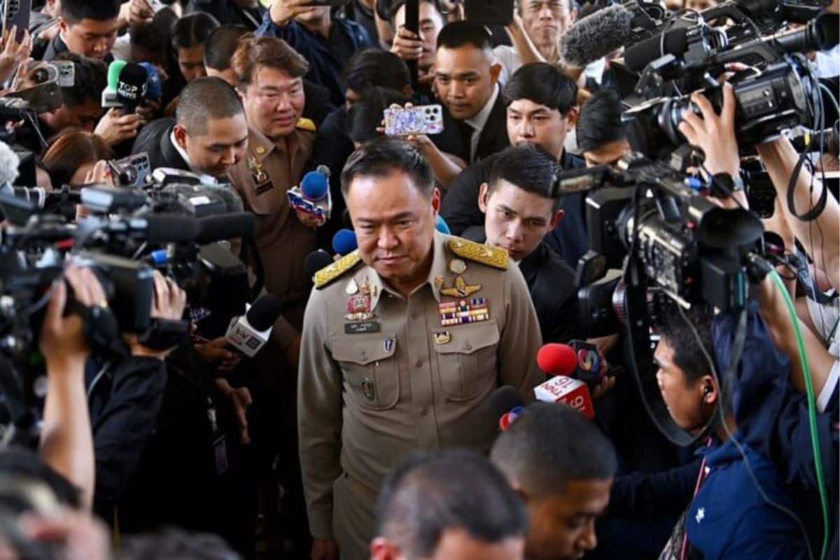 Prime Minister Anutin Charnvirakul surrounded by reporters during a press briefing.