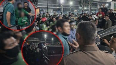 Delivery riders gather outside in mob police station after assault case | Thaiger