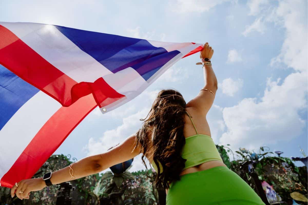 Woman running with Thai flag at Tomorrowland Thailand
