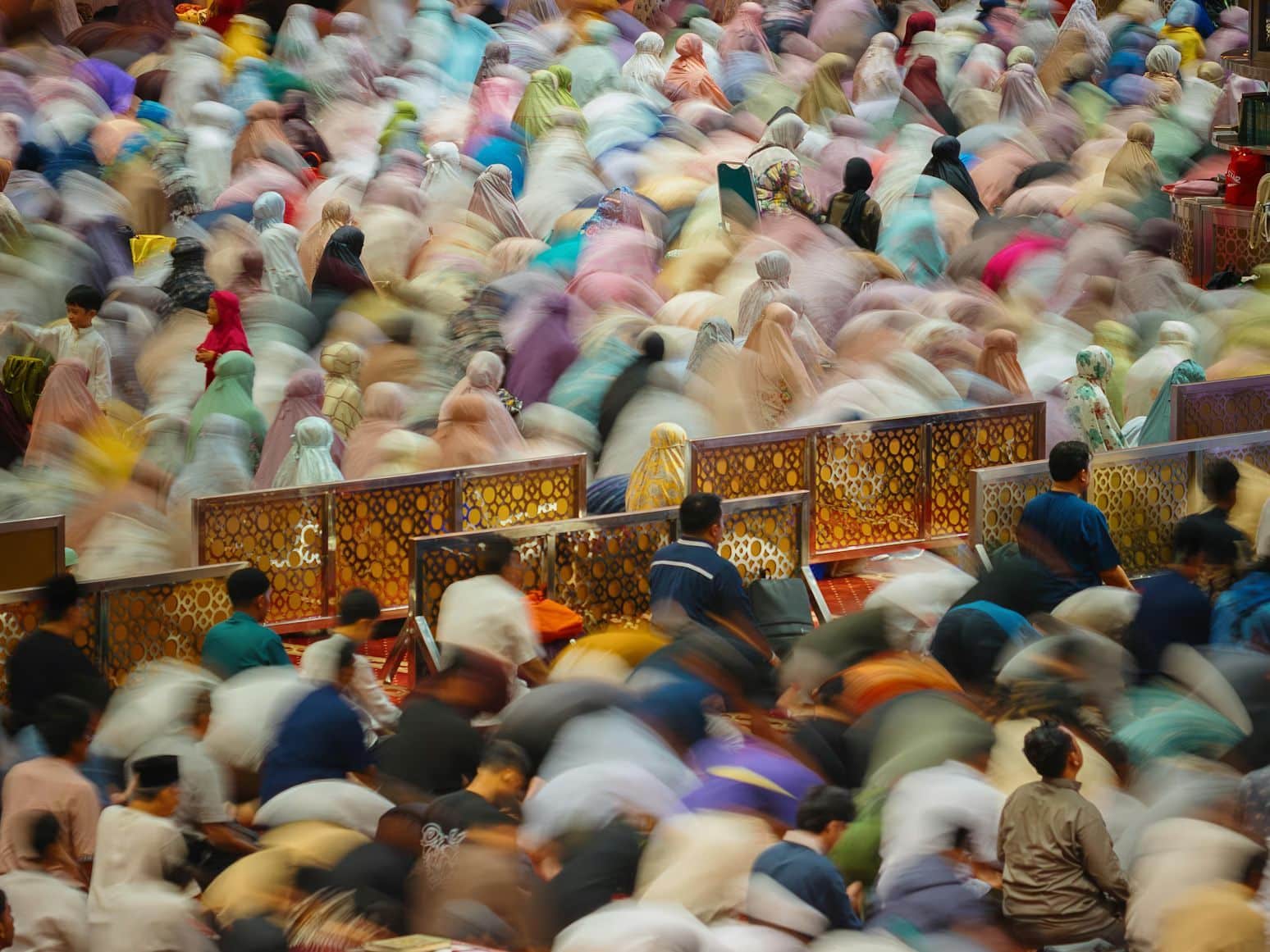 Blurred crowd of people praying together in unison during Ramadan