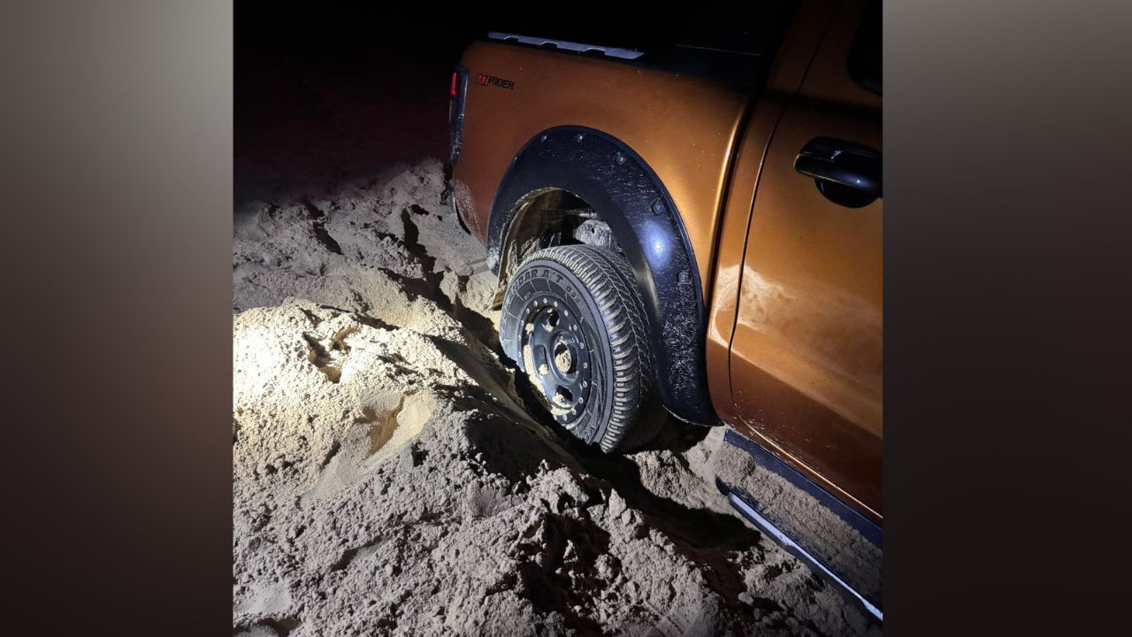 Pickup truck stuck in sand at Na Tai Beach in Phang Nga