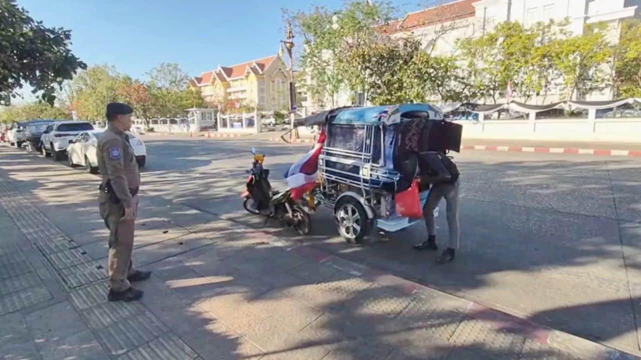Police officers speak with Japanese man Yamaguchi at Udon Thani shrine, with a birdcage nearby.