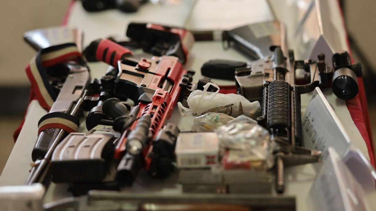 Police officers display seized M16 rifles and grenades during a raid in Nakhon Si Thammarat