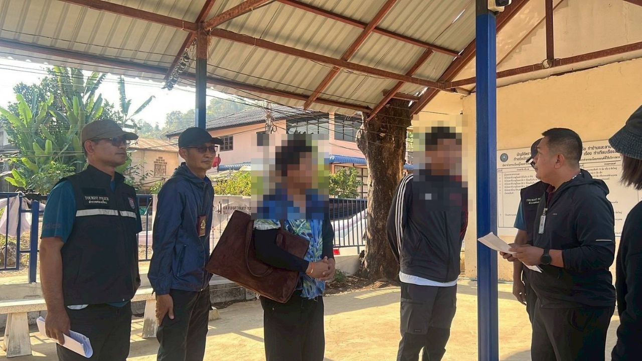 Tourism Police and Department of Tourism officials detain two men during an arrest at the Ban Khok Phai border checkpoint in Loei.