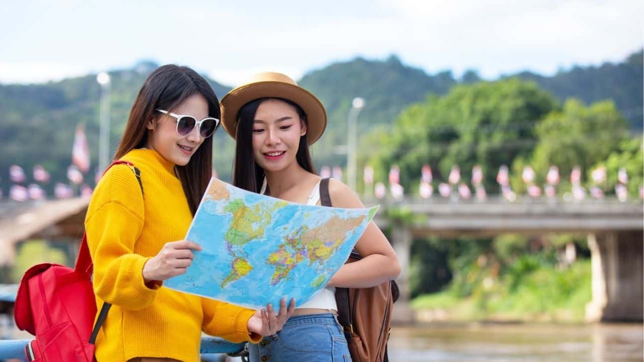 Two female tourists hold a map to find places