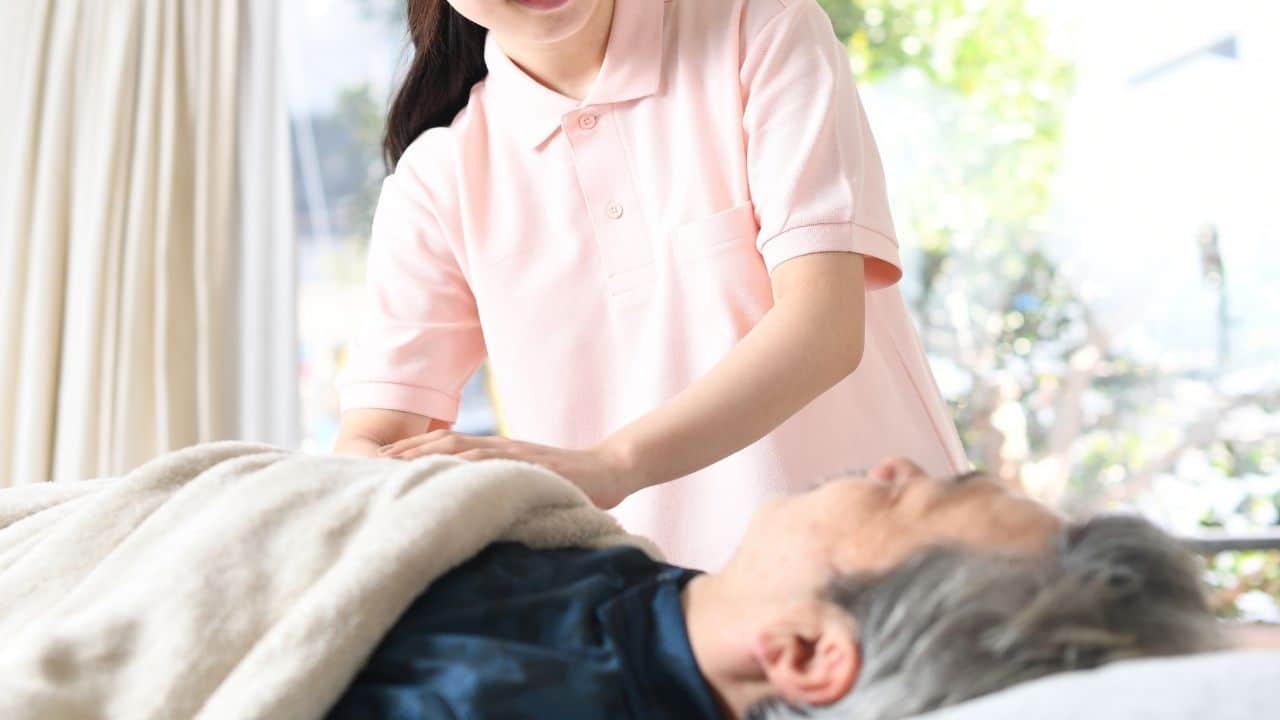 Caregiver taking care of bedridden patient